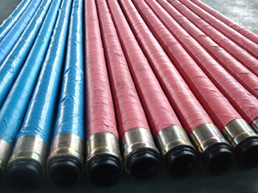 Many steel wire reinforced concrete pump hose assemblies are on the floor of the workshop.